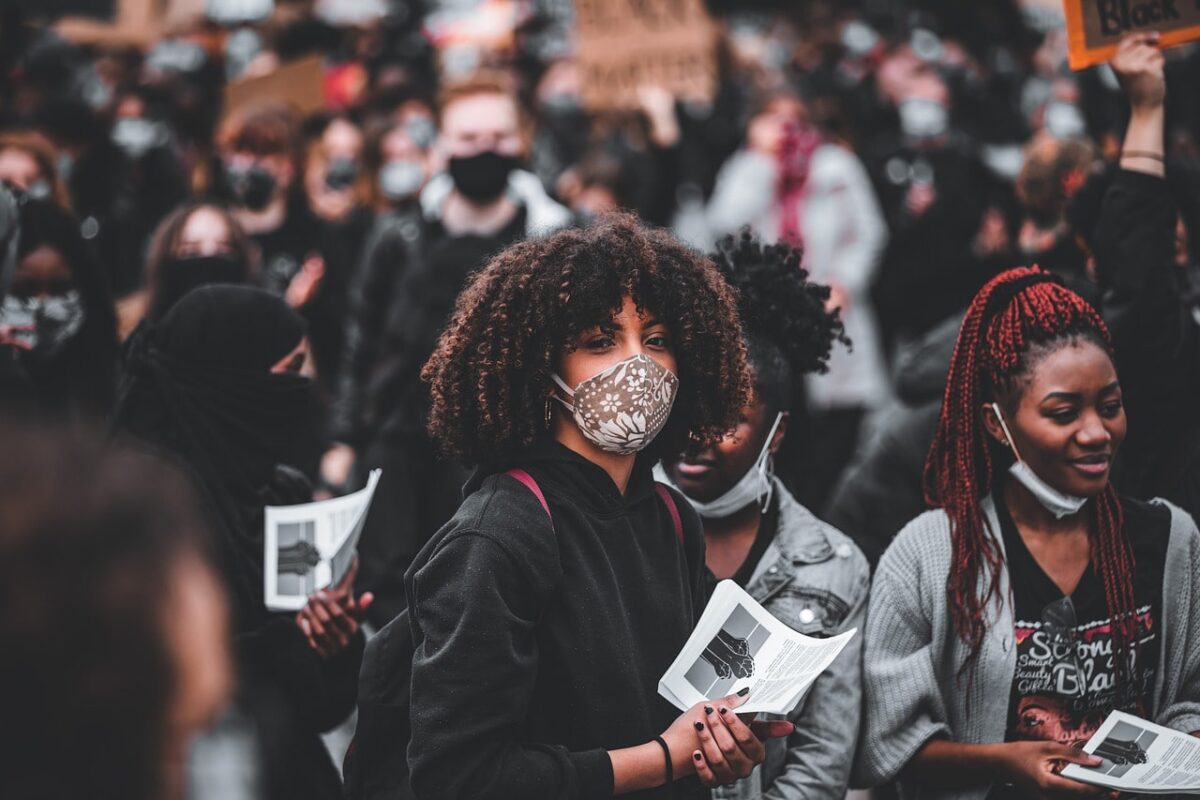 A group of diverse people with a girl wearing a mask in the center focus - An image used by A Better Concept PR - (ABCON PR)